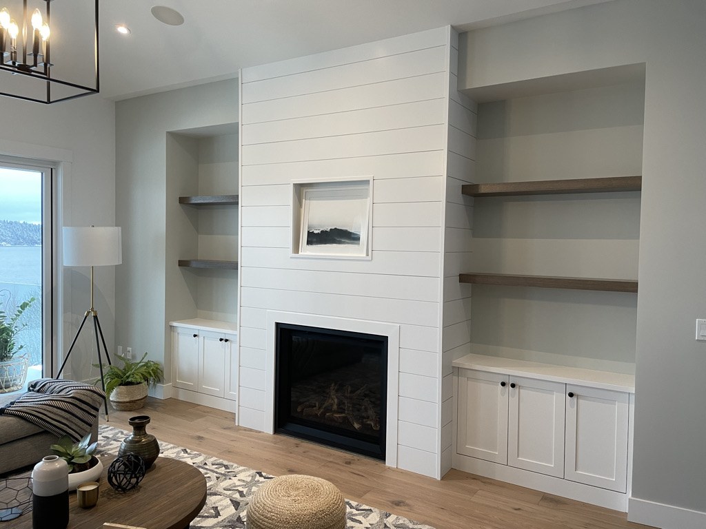 Shiplap fireplace wall with custom built in cabinets and floating shelves