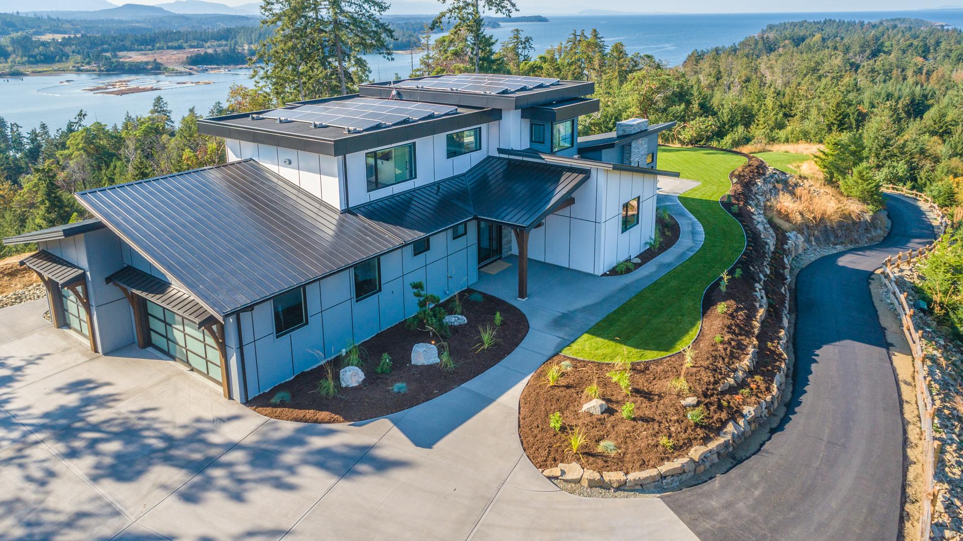 Aerial view of a custom home by VIP Homes on a hilltop lot overlooking the ocean near Qualicum Beach BC