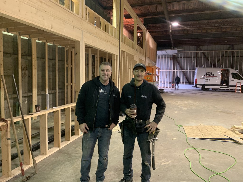Two VIP Homes crew members inside a shop build in progress