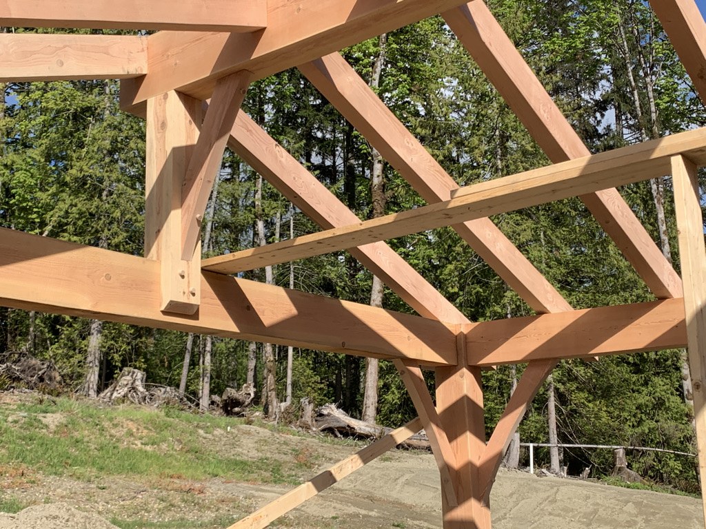 Douglas fir posts and rafters of a custom timber pavilion framed on site