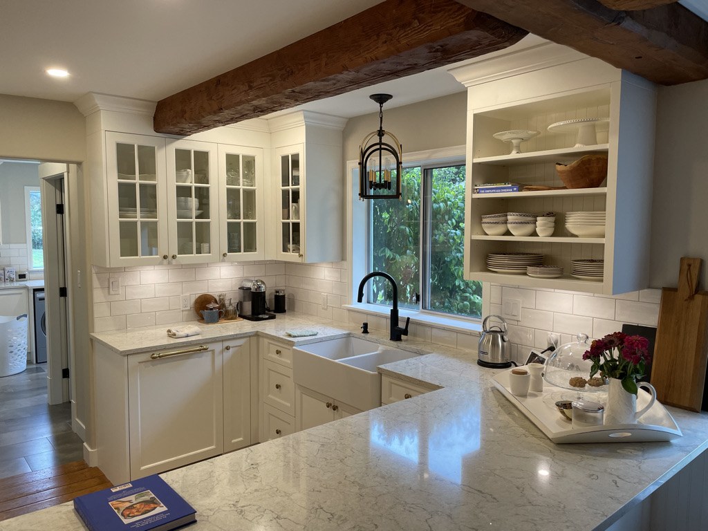 Country kitchen with a reclaimed beam, farmhouse sink and shaker cabinetry