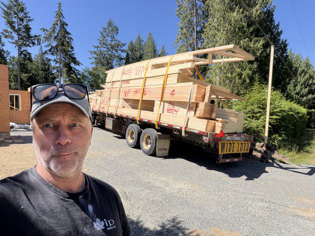 Roof trusses arriving on a flat deck truck at a VIP Homes site
