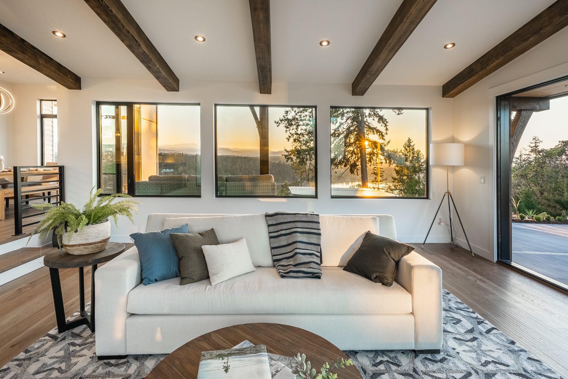 Living room with a low sofa, area rug and exposed timber beams overhead