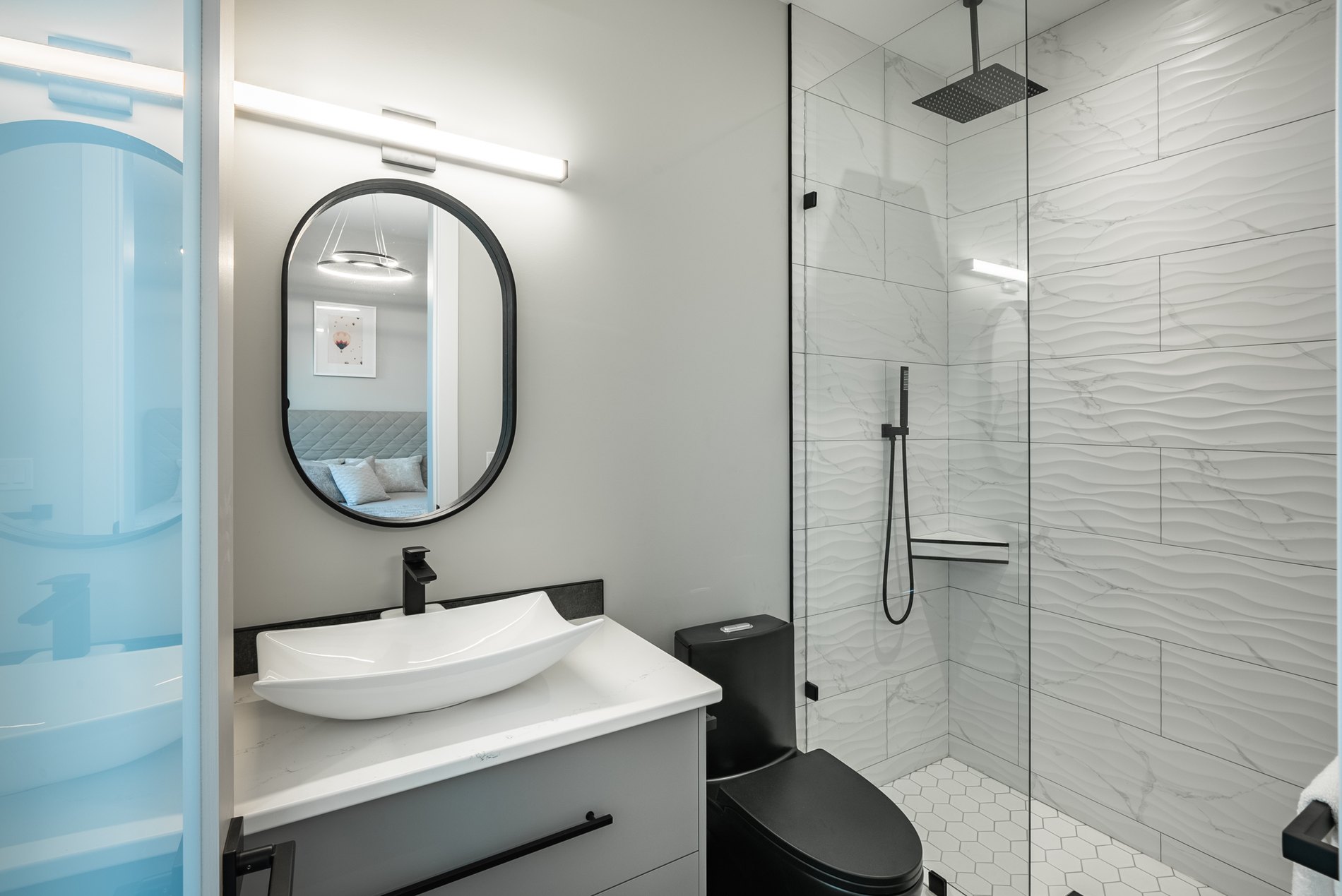 Guest bathroom with a vessel sink, black fixtures and a glass shower