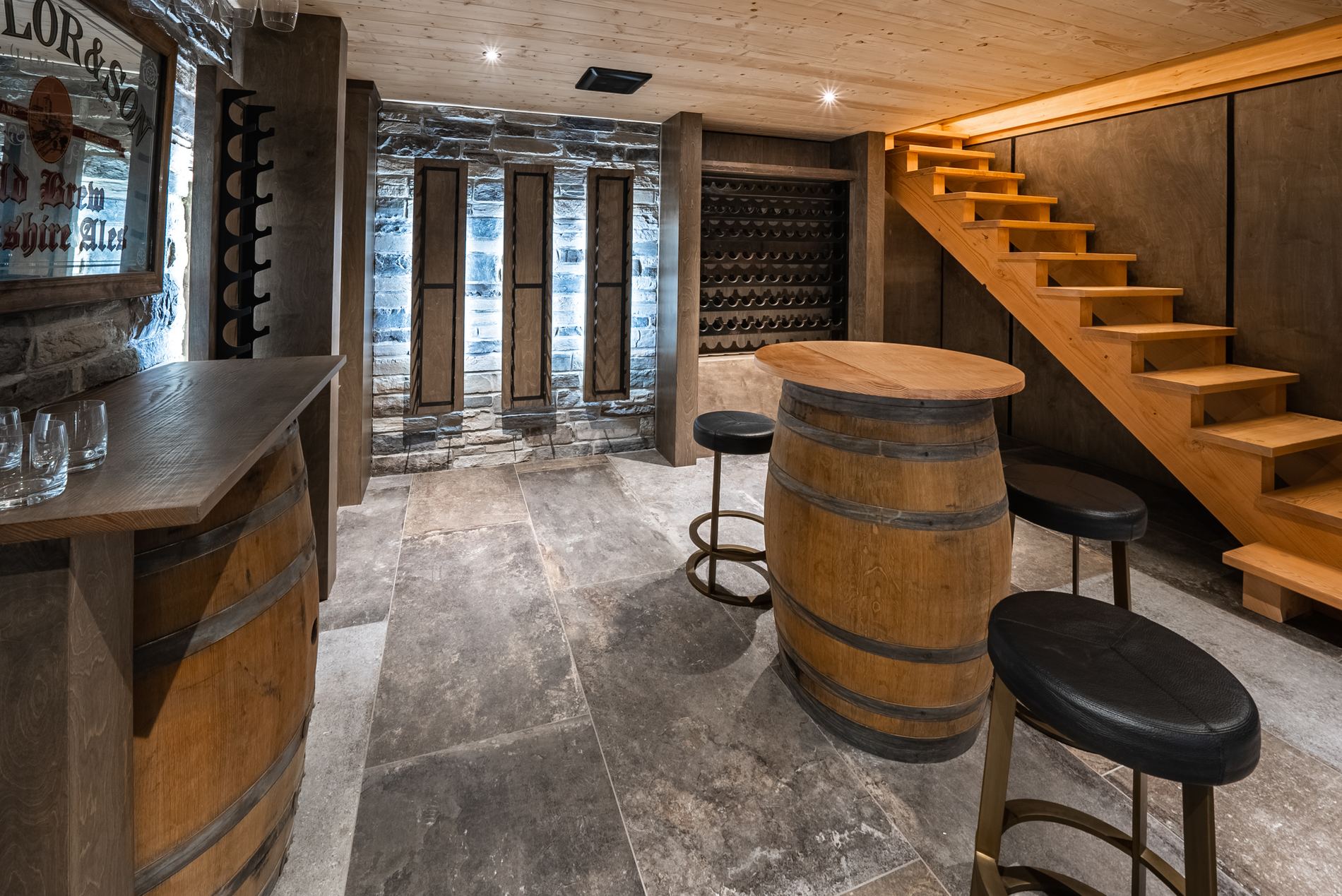 Custom wine cellar with a barrel table, timber racking and stone floors